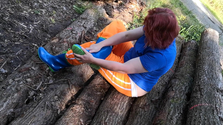 Bouncy Tits Action: Sitting in rubberboots on woodpile