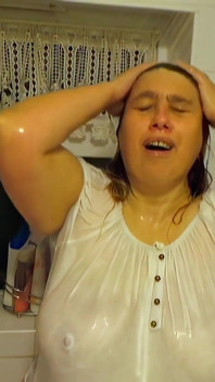 Pulchna i gospodyni pokazuje mokry T-shirt w wannie