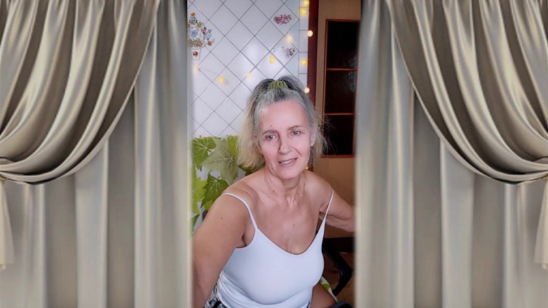 Lukerya: 一个开朗的家庭主妇在厨房洗衣机边跳舞，赤脚招手。