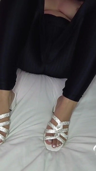 拉丁女郎穿着闪亮的高跟鞋在她性感的脚上做抹油足交