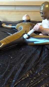 Latex Danielle is attached to the bed and masturbated with the massage vibrator