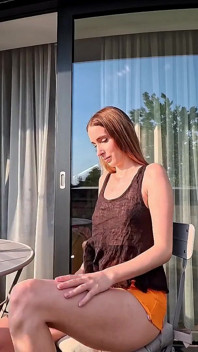 阳台上热辣的长腿性感美女在裙子下露出她的内裤，然后脱下内衣以显示紧致的阴户
