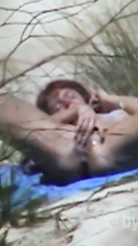 Redhead beauty dildoing pussy on the sandy beach