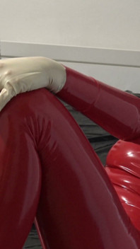 Fotoshoot in Rode Latex Catsuit Met Latex Masker En Transparant Gezicht.