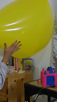 Marianna intenta inflar su globo cuadrado sin reventarlo