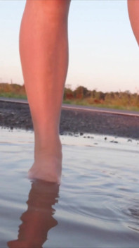 Bright Pantyhose and Beach Shoes in Puddle