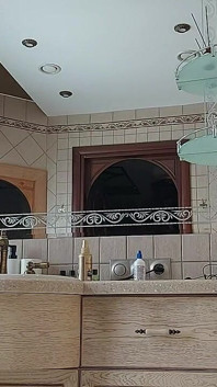 Seorang wanita menawan sedang preening di bilik air di hadapan cermin