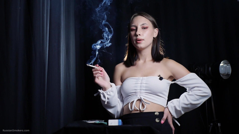 Russian Smokers: Elegante morena fumando cigarrillo en escena de estudio oscuro