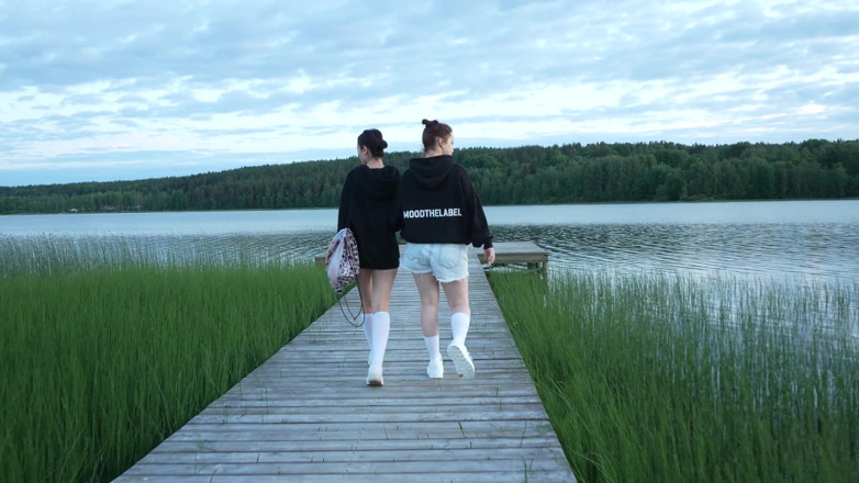 Apollon: Twee meisjes kleedden zich uit bij het meer. een passerende...