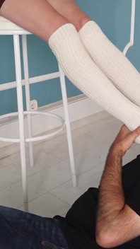 J'adore les pieds d'une jeune femme en longues chaussettes et pieds nus