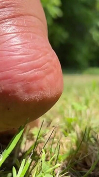 Stiefmutter barfuß draußen spielt im gras