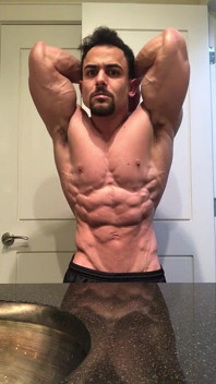 Jacked Fisiculturista Benji Bastian flexionando seu enorme, desfiado, músculos
