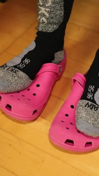 Rimozione di calze e gioco con scarpe intaso sotto la scrivania - leggings grigi, zoccoli rosa e calze di nylon
