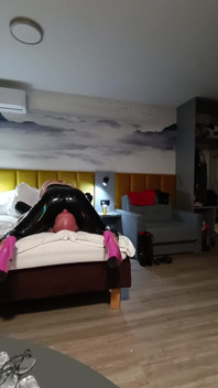 Godin Katrix zittend in gezicht in latexbroek provocatie