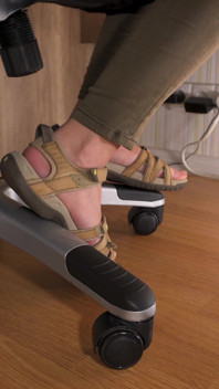 Liebe ihre füße in getragenen sandalen unter dem tisch