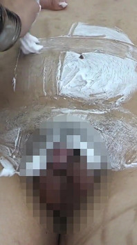 Chefin rasiert das schamhaar der männlichen Angestellten für Dessous-Modelle, zieht Dessous auf seinen Körpern und bräubt es mit heißem Wachs