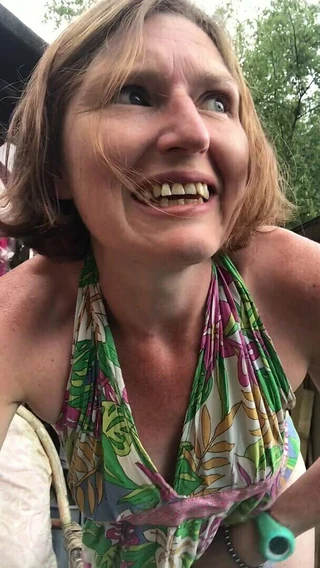 En primer plano - chica hippy super caliente y divertida mea en su jardín muy descuidado mientras se convierte en cascada de señorita de nuevo