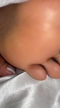 Ragazza ebano sotto le sue coperte a letto mostra i piedi
