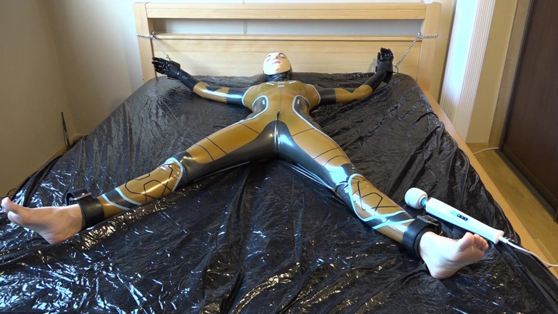 Latex Danielle: Latex Danielle is attached to the bed and masturbated with...