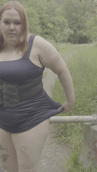 Une BBW rousse pisse à côté d’une barrière