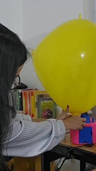 Marianna probeert haar vierkante ballon op te blazen zonder hem te barsten
