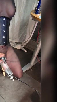 Domina Controls Blonde in Black Boots, Corset, Stockings, Frogtied with a Milking Cage to Extract Cum