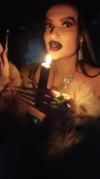 Een gothic heks verleidt je tijdens een winterse sneeuwstorm met haar zwarte magische rituelen, lange nagels en vacht.