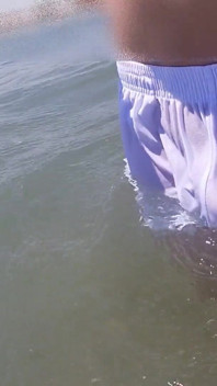 La gente sulla spiaggia viene fuori quando mi bagno con i pantaloncini