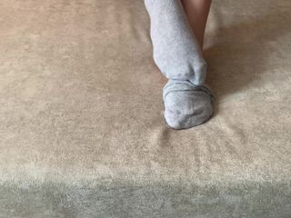 Gloria Gimson: Meisje streelt haar lange benen in grijze sokken