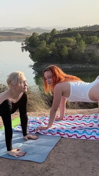 Açık havada yoga dersi: orta yaşlı seksi öğretmen ve genç öğrencisi