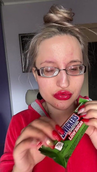 Gigante grandes lábios grandes óculos assreating snickers protein bar