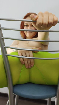 Teen tóc đỏ cảm thấy hứng tình trong chiếc quần tất màu xanh lá cây trên ghế