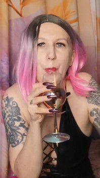 Lady Angela, déesse femdom, crache dans un glas puis le verse