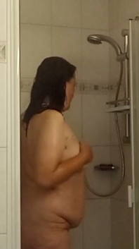 Mujer madura con pechos pequeños y trasero grande en la ducha