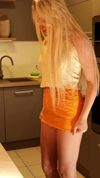 Fată sexy sexy cu picioare lungi frumoasă blondă drăguță studentă într-o fustă foarte scurtă care să-și expună curul și pizda în bucătărie