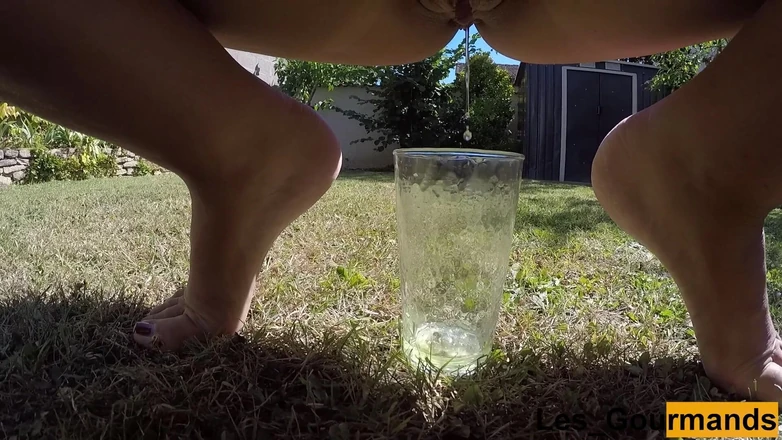 Les Gourmands: MILF Tans Naked Outside and Pissing in a Tall Glass