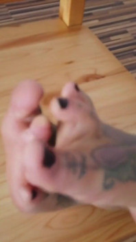 O doamnă blondă tatuată își arată picioarele