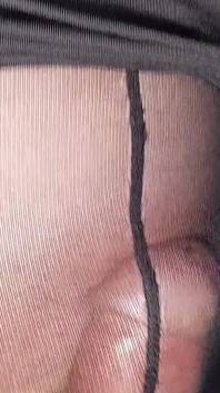 Pantyhose hitam dan sepatu hak tinggi muncrat di sofa