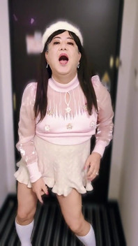Dans une jolie tenue féminine, elle se masturbe debout