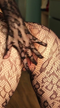 Je pose en body en résille noir et talons, je me donne du plaisir avec mes doigts