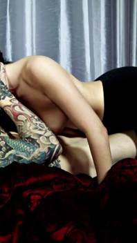 Gagica brunetă tatuată cu țâțe frumoase este forată pe pat
