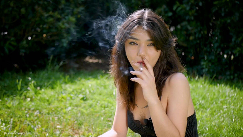 Russian Smokers: Arina Is Smoking One Black Cigarette Outdoors