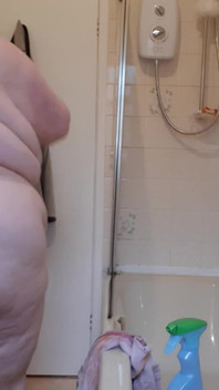 Une SSBBW nue nettoie le gros ventre de la salle de bain