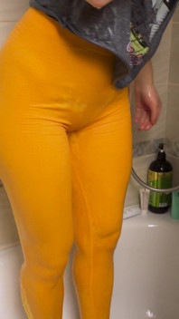 Amatoare asiatică în pantaloni de yoga strâmți se udă la duș