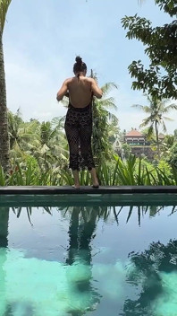 Provocando no vestido see-thru ao ar livre na piscina, strip