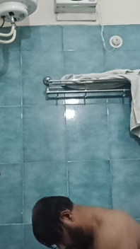 Un papà indiano nudo si gode una doccia calda e mostra il suo corpo bagnato
