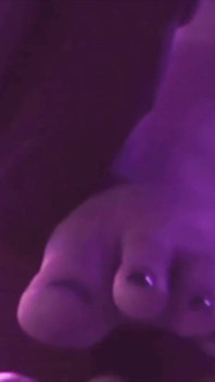 Young Girl Using Her Feet to Play with the Dildo While Masturbating