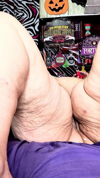 Onder haar flap komen doorhangende tieten klaar in haar schoot