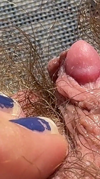 Fată păroasă amatoare se masturbează în prim-plan cu clitoris uriaș