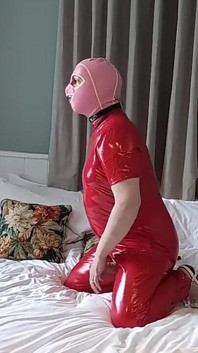 Una calda troia mascherata in una tuta piena di pvc rosso